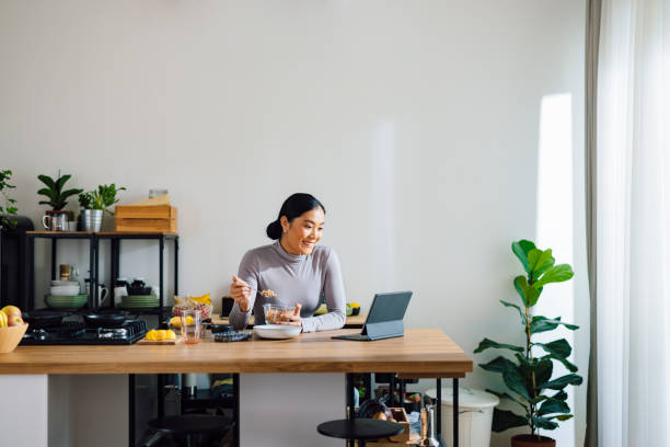istock Cheerful Woman Making Healthy Breakfast in Kitchen 1358132387