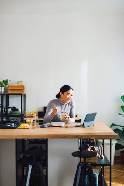 istock Cheerful Woman Making Healthy Breakfast in Kitchen 1358132388