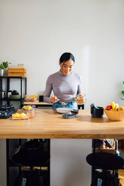 istock Smiling Woman Making Healthy Breakfast in Kitchen 1358132393