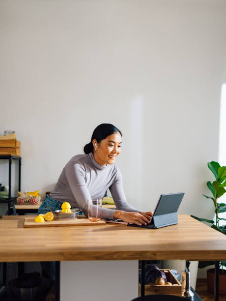 istock Happy Woman Talking on Video Call while Making Healthy Breakfast in the Kitchen 1358132399