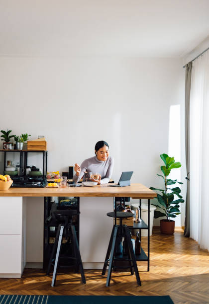 istock Cheerful Woman Making Healthy Breakfast in Kitchen 1358132400