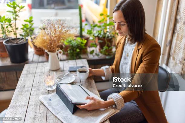 Businesswoman Sitting At A Coffee Shop Using Digital Tablet Stock Photo - Download Image Now