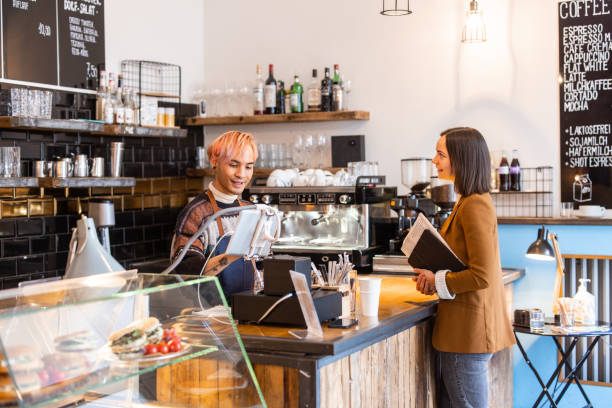 istock Barista taking order from a woman customer at checkout counter 1358132708