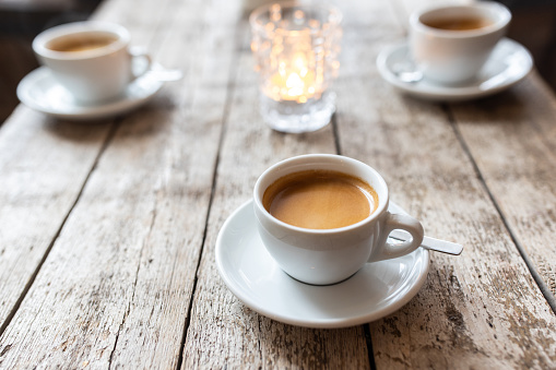 Coffee cups on wooden table. Close-up of white coffee cups on cafe table.