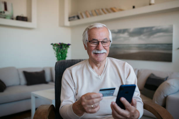 istock Happy senior Caucasian man shopping from home using a smart phone 1358139067