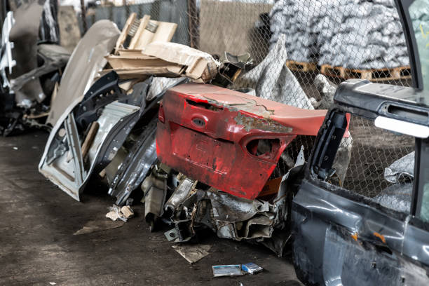 mucchio di vecchie parti di auto smontate arrugginite nell'hangar di stoccaggio dei rifiuti dell'officina al coperto. garage di smontaggio di salvataggio del veicolo. pile di ricambio per auto in ferro per il riciclaggio presso la discarica di rottami - vehicle door rusty old fashioned old foto e immagini stock