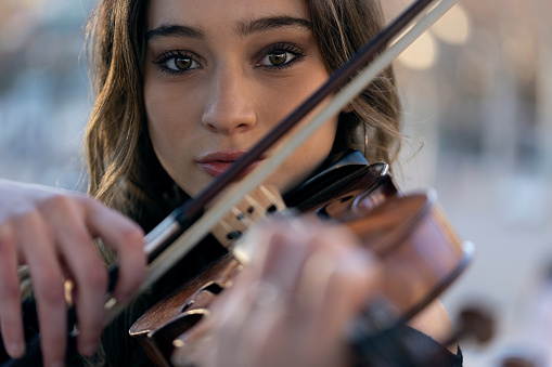 portrait of young violinist girl looking directly at camera