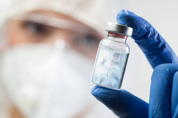 istock Cell division process conceptual illustration,lab scientist holding ampoule vial with DNA cell nucleus molecules splitting 1358143769