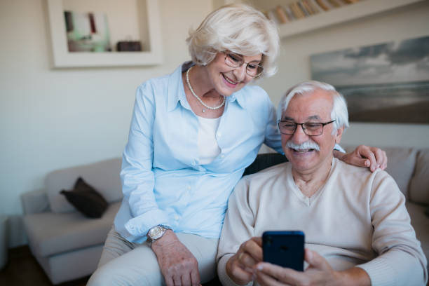 istock Happy senior Caucasian couple using a smart phone at home 1358150391