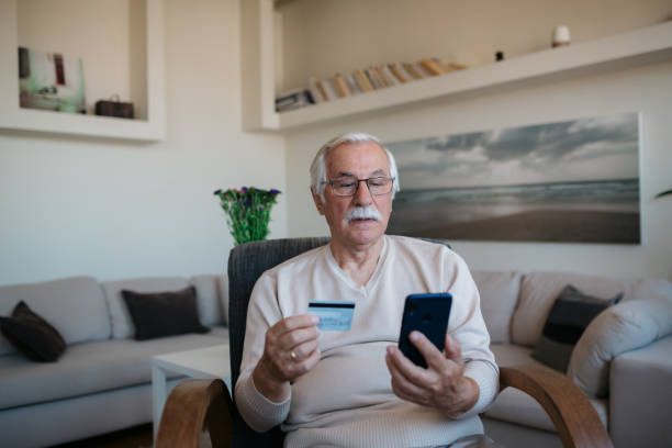 Elderly Caucasian man shopping online from home stock photo