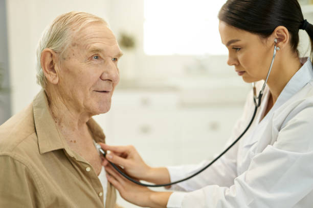 istock Qualified medic examining senior man lungs with stethoscope 1358150734
