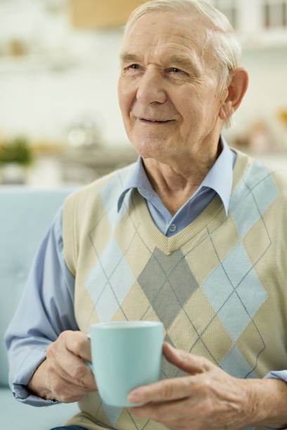 istock Smiling elderly man relaxing at home with a cup of hot tea 1358152653