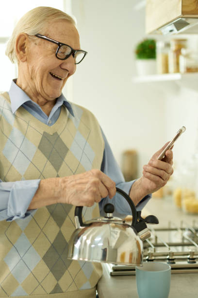 istock Likeable aged man contacting someone online from his kitchen 1358152694