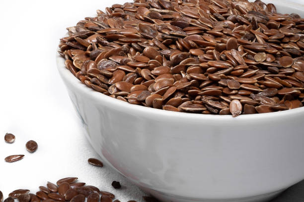 istock Flax seeds in a white cup on a white background. 1358152815