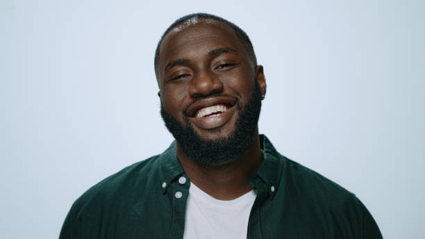 istock Closeup african handsome guy smiling at camera in studio. Afro man posing 1358152901