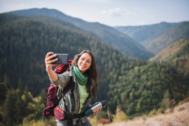 istock Young Woman Taking Selfie While On A Hike 1358154528