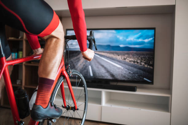 istock Man Riding Bike At Home With Simulation Trainor 1358154539