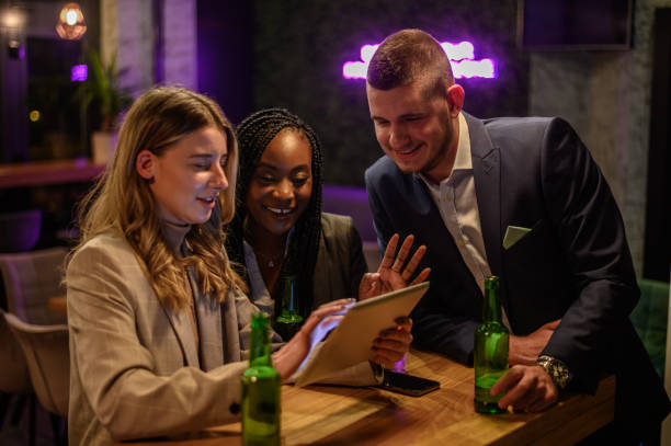 istock Cheerful colleagues drinking beer in the bar together after work 1358154900