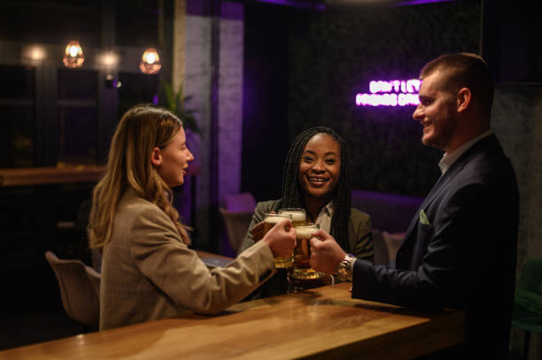 istock Cheerful colleagues drinking beer in the bar together after work and using a tablet 1358154918