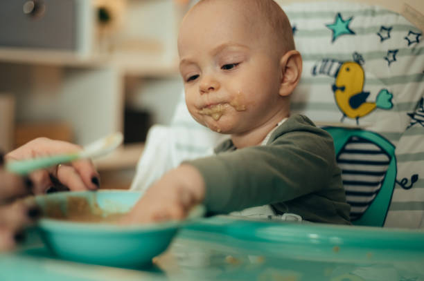 istock Adorable little baby eating his dinner and making a mess 1358154921