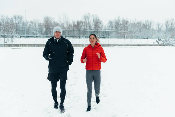 istock Young couple going for a run together during a snow 1358154926