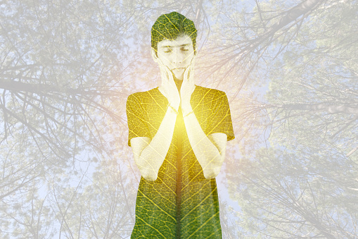 Double exposure of relaxed young man coexists with nature.
