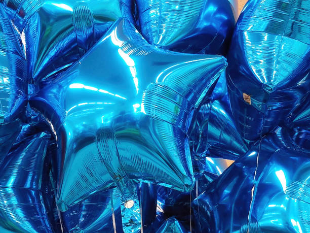 Group Of Metallic Star Shaped Helium Balloons Close up of a group of shiny blue metallic star shaped balloons. helium balloon stock pictures, royalty-free photos & images