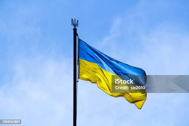 Ukrainian Flag In The Rays Of The Rising Sun On A Background Of Sky Bicolor Blue And Yellow National Flag Of Ukraine On A Flagpole And Coat Of Arms Of Ukraine Trident Official Symbol Of Ukraine Stock Photo - Download Image Now