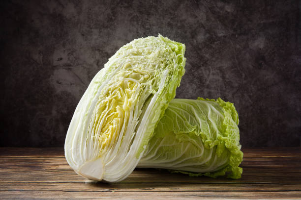 istock fresh chinese cabbage and a cut one on wood background 1358162854
