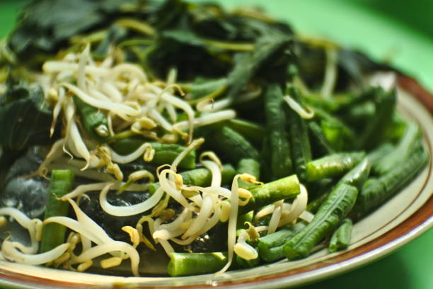 close up photo of sweet potato leaves, long beans and boiled bean sprouts for making pecel rice, a typical food from East Java, Indonesia