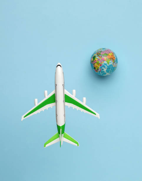 istock A plane flying over the globe on a blue background. Flat lay. 1358168284