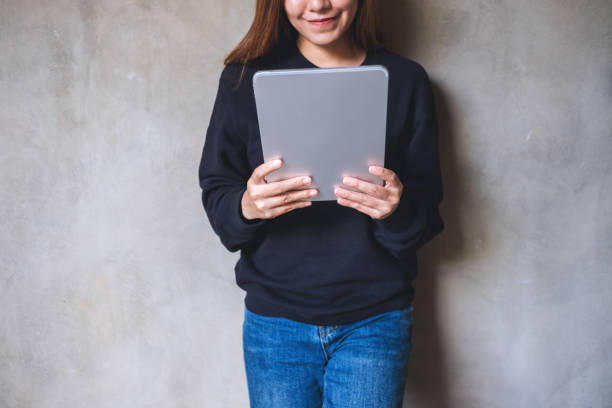 istock Closeup of a young woman holding and using digital tablet 1358170792