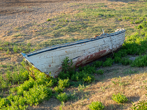 Abandoned wooden boat laying on the ground