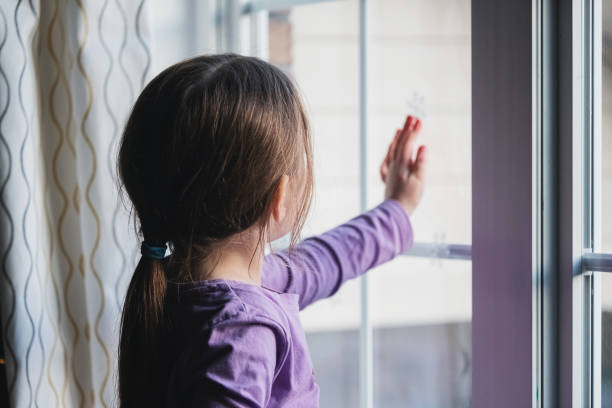 istock Girl Decorates Living Room Window 1358172567