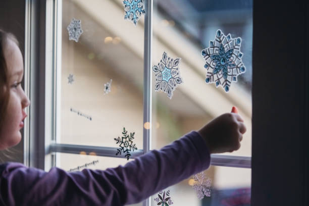 istock Girl Decorates Living Room Window 1358172571