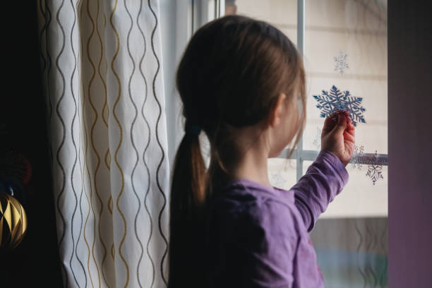 istock Girl Decorates Living Room Window 1358172573