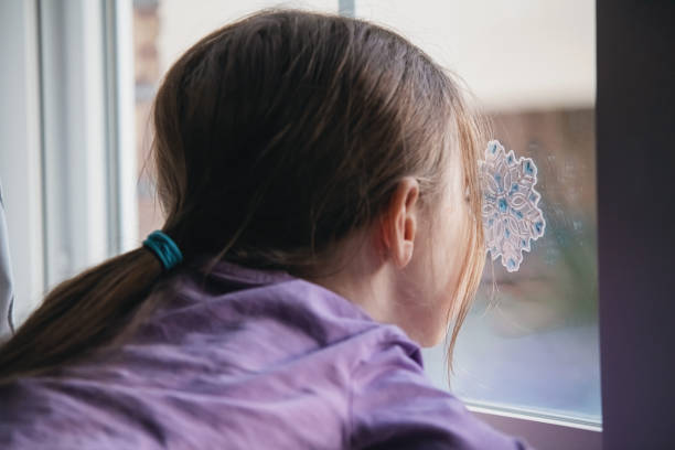 istock Girl Decorates Living Room Window 1358172579
