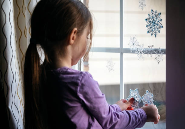istock Girl Decorates Living Room Window 1358172580