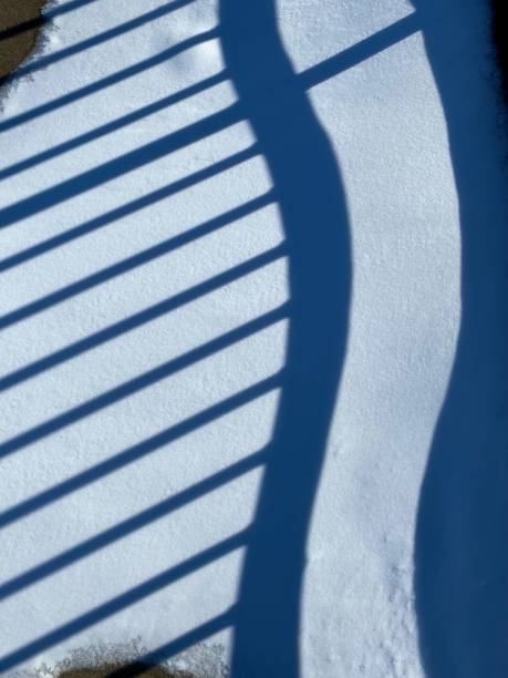 istock Snow shadow of railing on lighthouse pier in Michigan. 1358173995