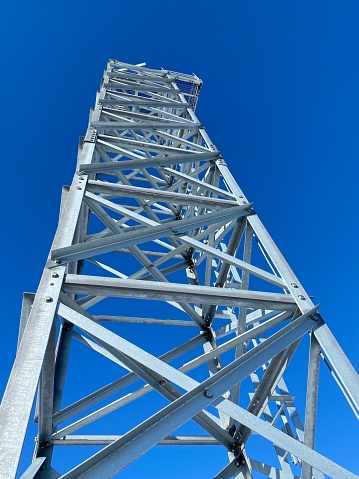 Metal tower on a pier in Upper Michigan in Menominee Michigan in The Upper Peninsula. Only the tower can be seen and the sky, low angle view looking up in this Black and white photograph.