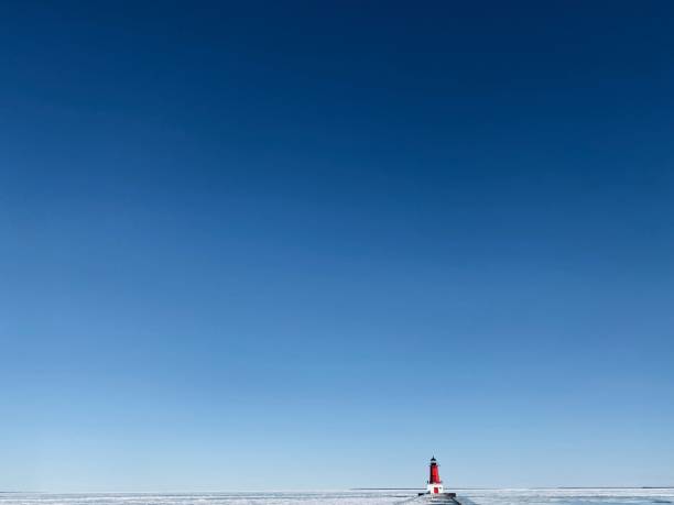 Ann Arbor lighthouse and pier in the winter with lots of blue sky. Taken in Menominee, Michigan in The Upper Peninsula of Michigan. stock photo
