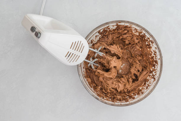 istock Bowl of chocolate cream, mixing ingredients using an electric mixer. Baking process, close up view from above, copy space 1358174827
