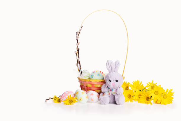 istock Happy Easter! Easter basket with flowers, eggs and cute bunny isolated on white background. 1358175559