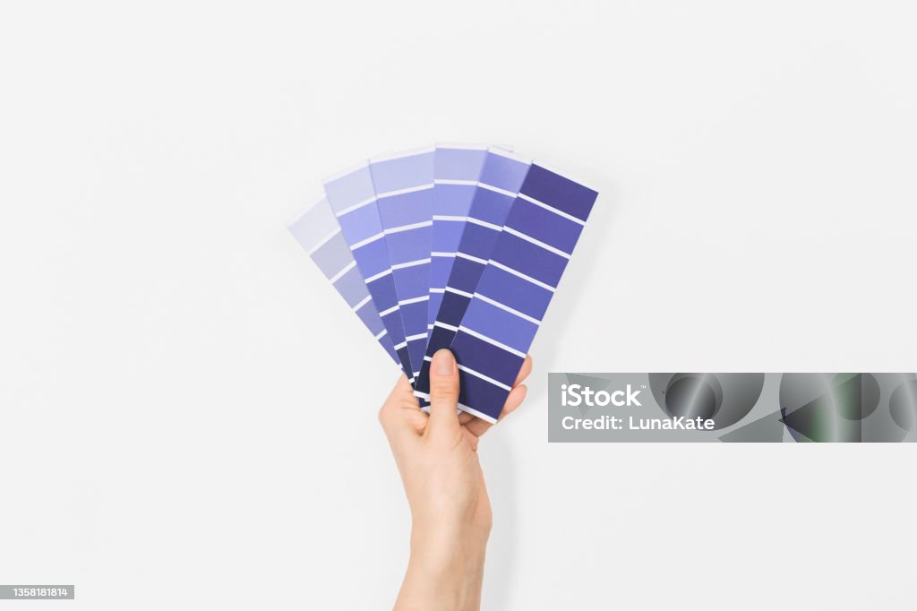 Color swatches with color of the year 2022 in the hand - Very Peri. Color trend palette. Top view, flat lay. Color Swatch Stock Photo