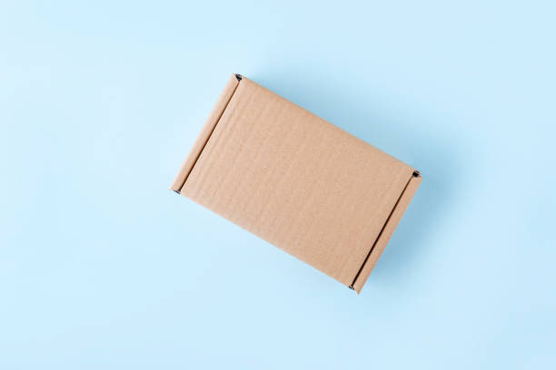 istock Blank cardboard box package on blue background. Craft paper box for gift. Shipping eco package. Delivery pack, plastic free. Mock uo, copy space for 1358183336