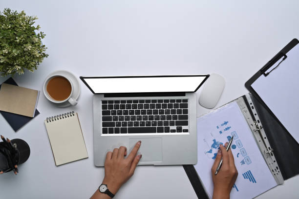 istock Above view businesswoman working with laptop computer and analyzing financial document. 1358184425