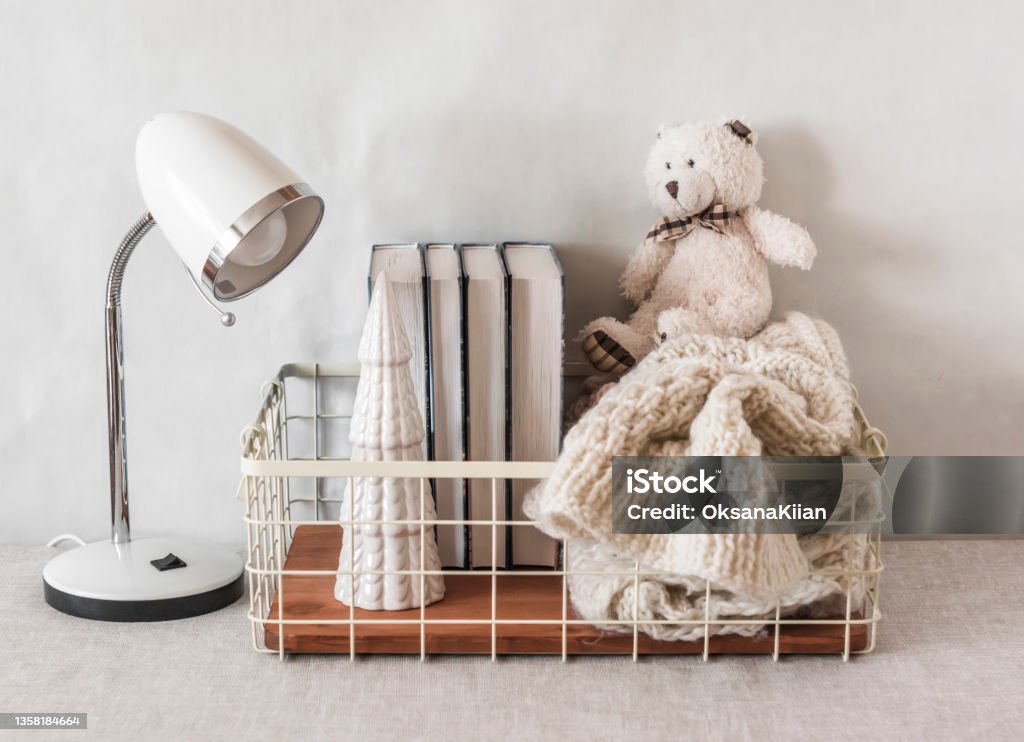 Children's room interior. A table lamp, a basket with books and toys on the table. Scandinavian style simple interior Apartment Stock Photo