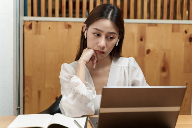 istock Attractive young Asian female student looking at laptop while studying online course. 1358186142