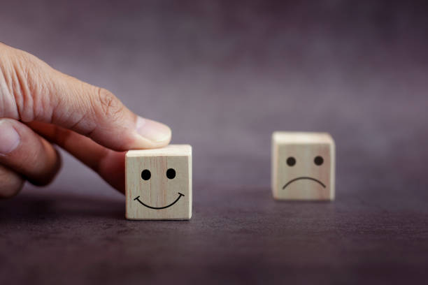istock Close up customer hand choose smiley face and blurred sad face on wood cube. 1358188210