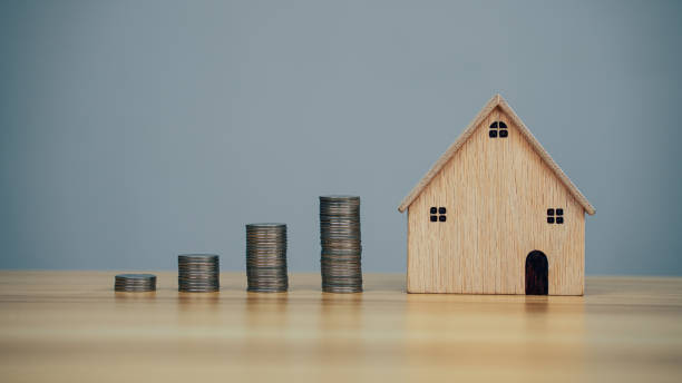 istock Saving money model house and coins on wood table background 1358188446
